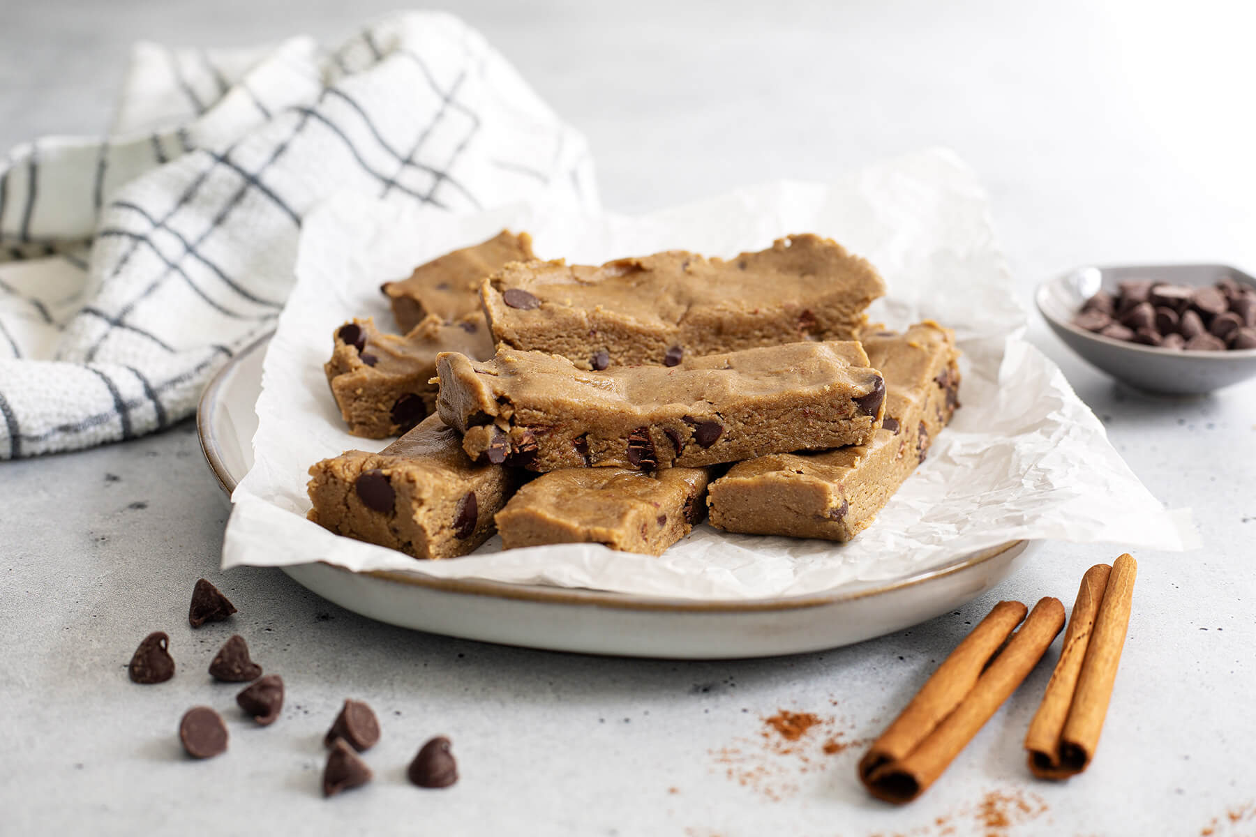 Sliced no-bake lunchbox bars made with sunflower seed butter, oats, and mini chocolate chips, arranged on parchment paper.