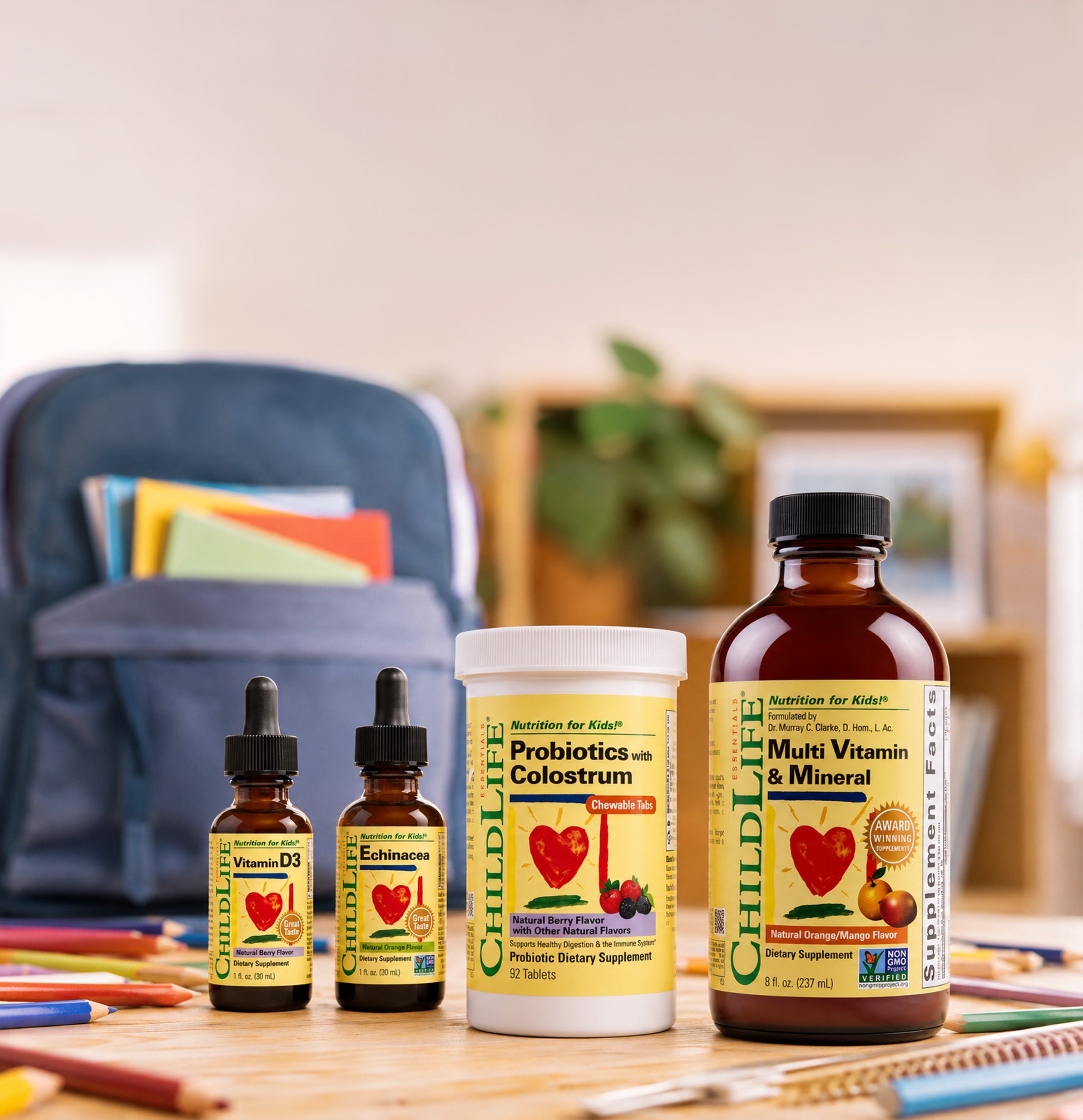 Four ChildLife Nutrition products arranged on a wooden table along with colored pencils and a backpack