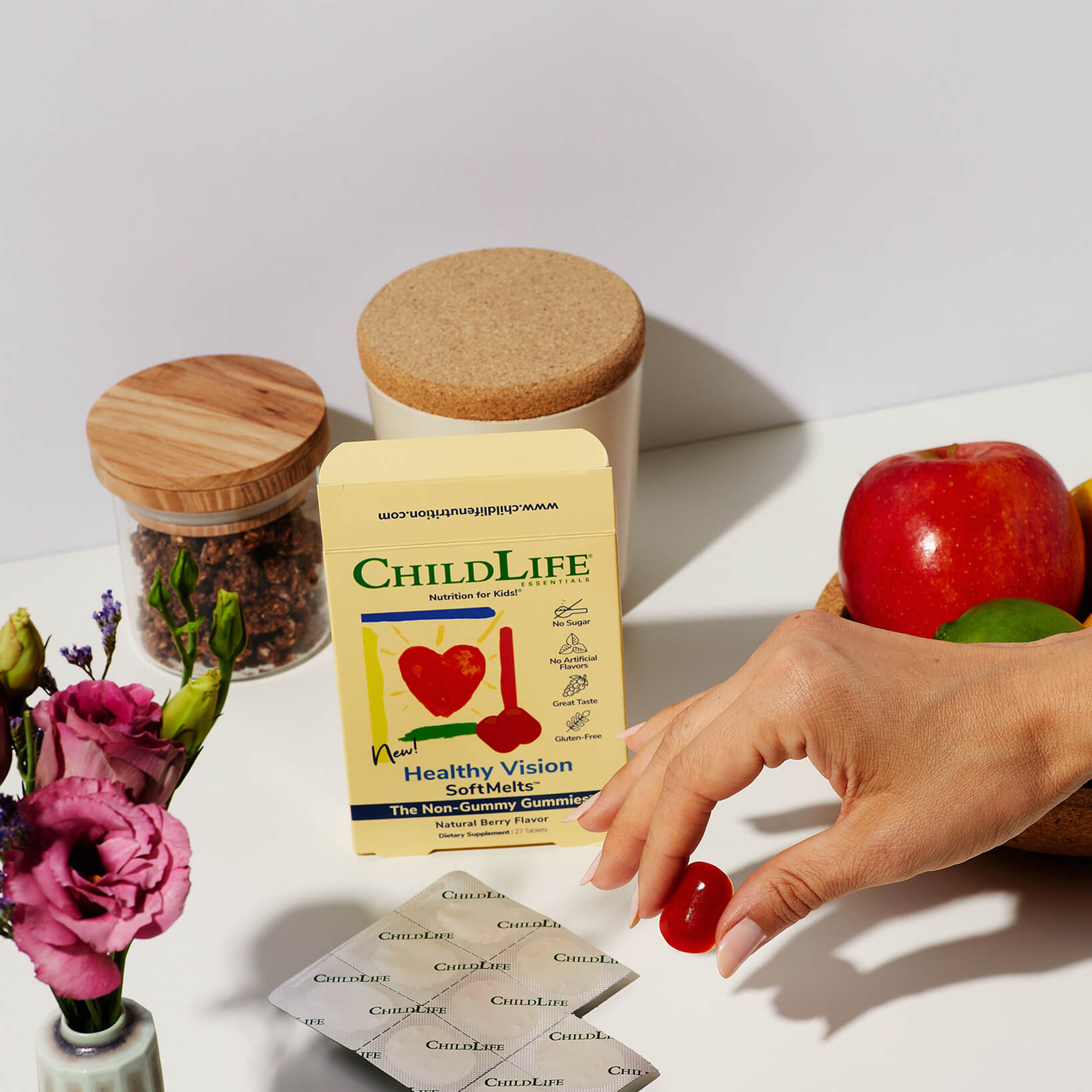 Childlife Healthy Vision SoftMelts on a counter with a hand picking up a softmelt.