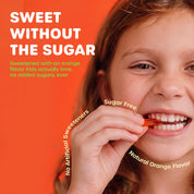 A close-up of a child taking bite of a ChildLife Multi Vitamin SoftChew Gummy with text about sugar-free orange flavor sweeteners.